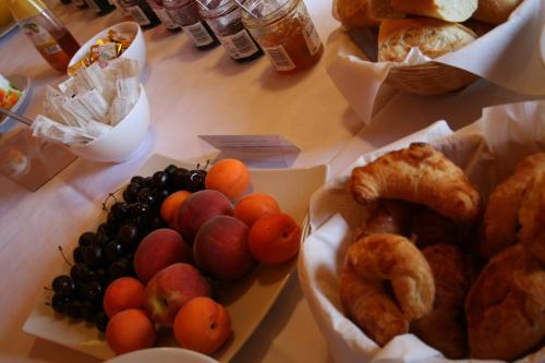 a table topped with baskets of fruit and pastries at Hôtel Valery in Montélier