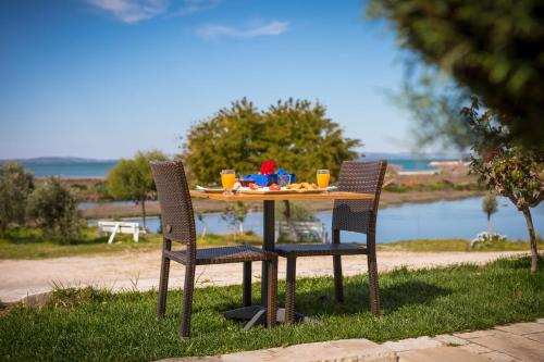 a table with two chairs and a table with drinks at Koronisia Apartments in Koronisia