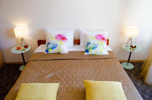 a bedroom with a large bed with two tables at City Inn Riga Apartment, Town Towers with parking in Rīga