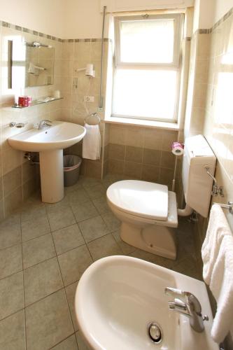 a white bathroom with a sink and a toilet at Hotel Nel Pineto in Montesilvano