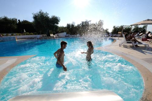 a man and a woman playing in a swimming pool at Zagare Residence in Rodi Garganico
