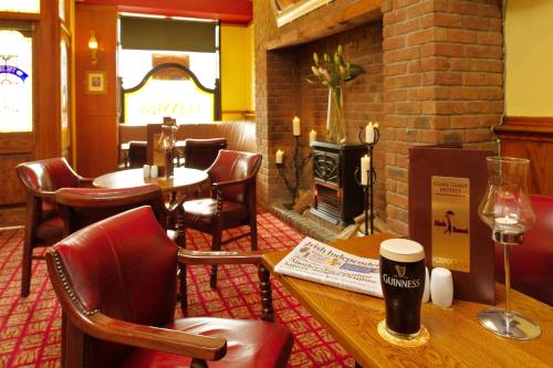 a restaurant with a table and chairs and a fireplace at Shamrock Inn Hotel in Lahinch