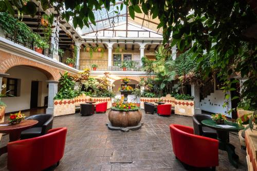 a greenhouse with tables and chairs and plants at El Carmen Hotel in Antigua Guatemala