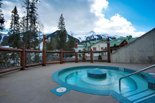 een zwembad op een patio met bergen op de achtergrond bij Lizard Creek Lodge in Fernie