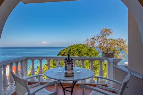 a table on a balcony with a view of the ocean at Saltwater Serenade Apartments in Zakynthos