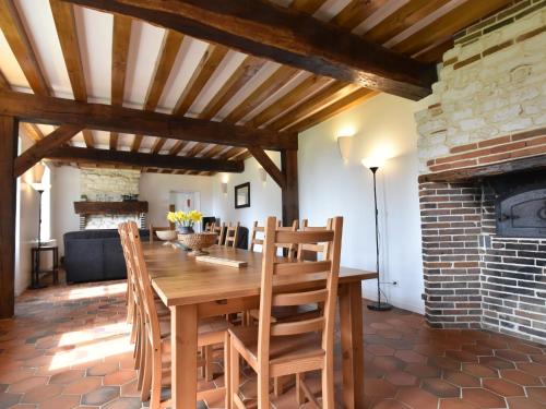 a dining room with a wooden table and a fireplace at Spacious holiday home in Sormery with pool in Sormery