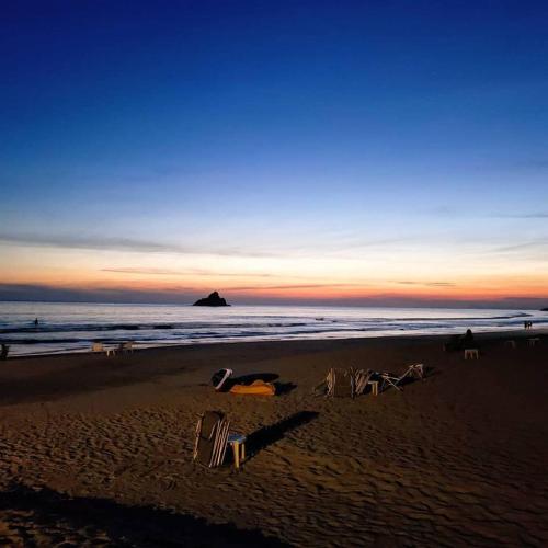a beach with two lawn chairs and the ocean at Mares de Camburizinho in Camburi