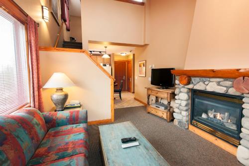 ein Wohnzimmer mit Couch und Kamin in der Unterkunft Lizard Creek Lodge in Fernie