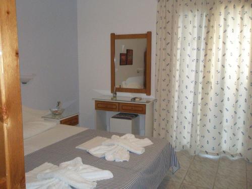 Ionio Gastronomy Suites في أموديا: غرفة الفندق بسرير ومرآة