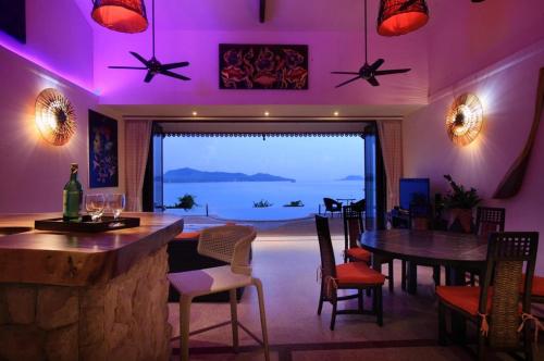 a room with a bar and a view of the ocean at 5 Bedroom Seafront Villa Phangan SDV231-By Samui Dream Villas in Srithanu