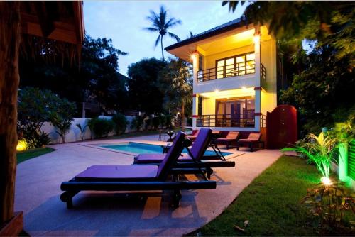 a group of lounge chairs in front of a house at 3 Bedroom Seaview Island View Koh Phangan SDV233-By Samui Dream Villas in Srithanu