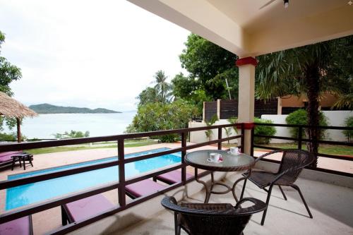 a balcony with a table and chairs next to a swimming pool at 3 Bedroom Seaview Island View Koh Phangan SDV233-By Samui Dream Villas in Srithanu