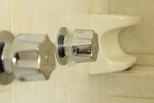 a metal door knob on a toilet in a bathroom at Hotel Avenida in Acapulco