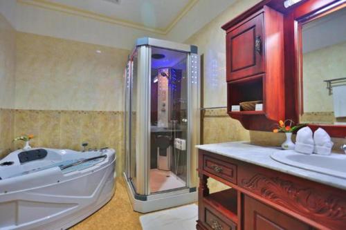 a large bathroom with a shower and a tub at Centauria Hill Resort in Ratnapura