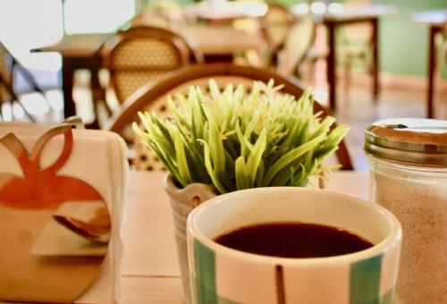 a cup of coffee sitting on a table with flowers at Santa Maria del Cabo in San José del Cabo