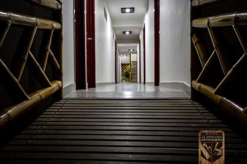 an empty corridor in a building with benches at Hotel la Embajada Antioqueña in Cúcuta
