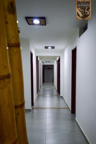 a hallway with white walls and a long hallway with white floors at Hotel la Embajada Antioqueña in Cúcuta