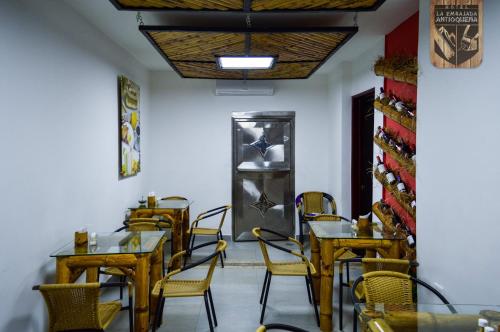 a dining room with tables and chairs and a door at Hotel la Embajada Antioqueña in Cúcuta