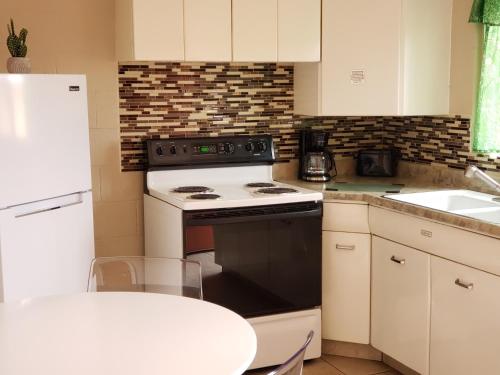 
a kitchen with a stove a refrigerator and a microwave at Red Rock Motel in Page
