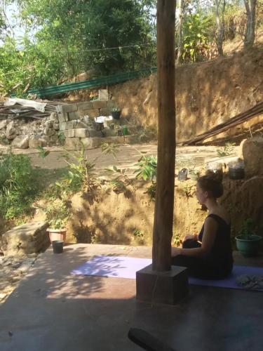 a woman sitting on the floor next to a pole at Ella green stay in Ella