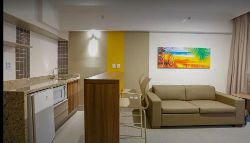 a living room with a couch and a kitchen at Apartamento em Resort de Olimpia in Olímpia