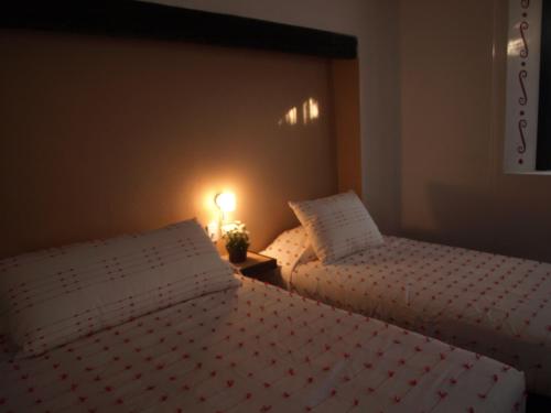 two beds in a bedroom with a lamp on a table at Hotel Boutique La Casona de Don Porfirio in Jonotla