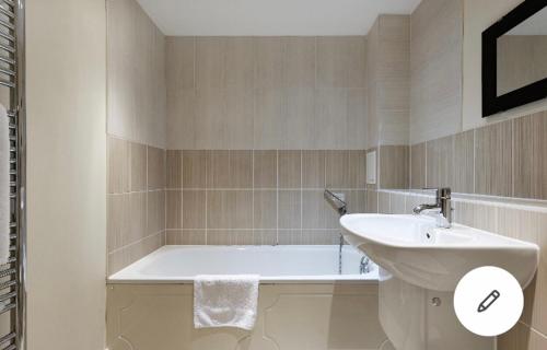 a bathroom with a sink and a bath tub at Copperfield Apartment in Canterbury