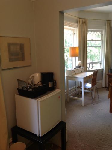 a living room with a desk and a table with a table at Barclay House Bed and Breakfast in Vancouver