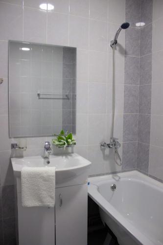 a white bathroom with a sink and a bath tub at Апарт отель Welcome in Taldykorgan