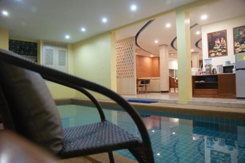 a chair sitting next to a swimming pool at Happy Hostel in Pattaya Central