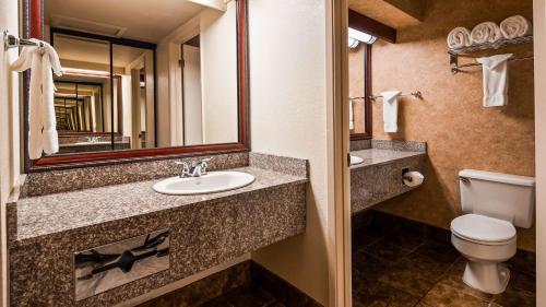 a bathroom with a sink and a toilet and a mirror at Best Western Plus Humboldt House Inn in Garberville