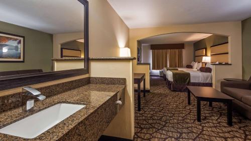 Habitación de hotel con cama, lavabo y espejo en Best Western PLUS Vancouver Mall Drive, en Vancouver