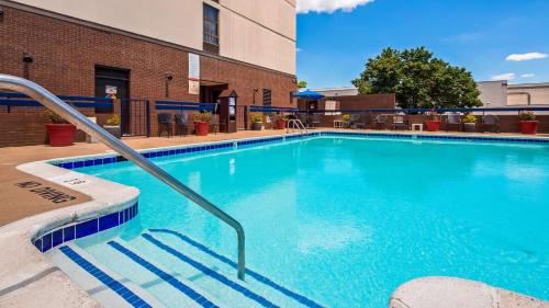 una piscina de agua azul frente a un edificio en Best Western Potomac Mills en Woodbridge