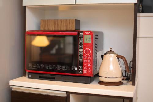 a microwave sitting on top of a kitchen shelf at Fuji Time traveler 新館 in Fujikawaguchiko