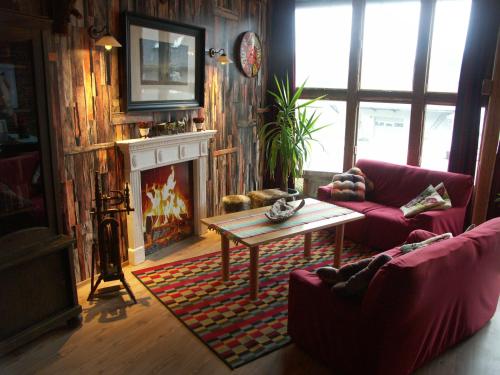 een woonkamer met een bank, een tafel en een open haard bij Bed And Breakfast Isidorus in Winterberg