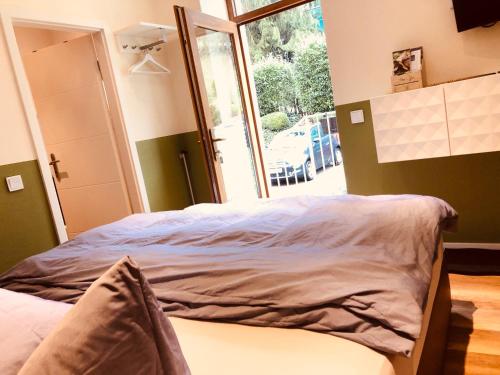 a bed in a room with a large window at business-lodging Apartmenthaus in Höhr-Grenzhausen