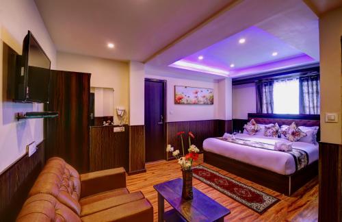 een slaapkamer met een bed en een bank in een kamer bij Hotel White Yak in Darjeeling