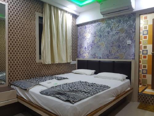 a bedroom with a large bed with a mirror at Hotel Laabh in Diu