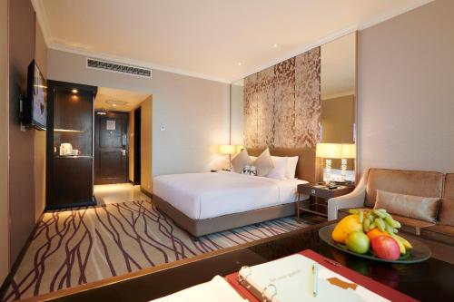 a hotel room with a bed and a couch at Dorsett Kuala Lumpur in Kuala Lumpur