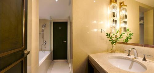 a bathroom with a sink and a shower and a tub at Dorsett Kuala Lumpur in Kuala Lumpur