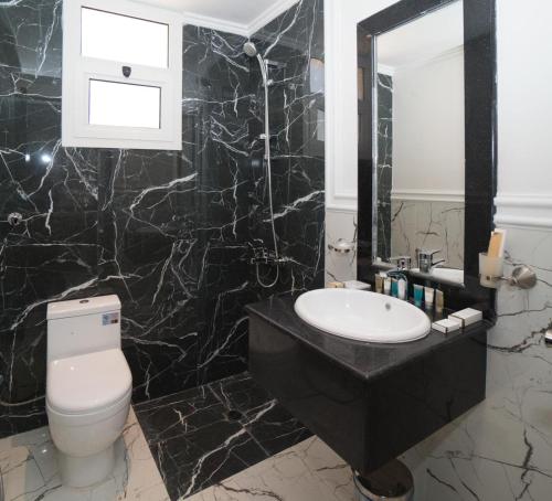 a black marble bathroom with a toilet and a sink at Maset Al Masem Al Khobar in Al Khobar