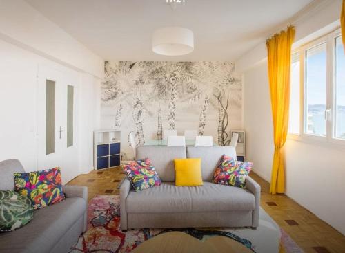 a living room with a couch and yellow curtains at Stunning 2 bed Flat Nice front of the beach Seaview in Nice