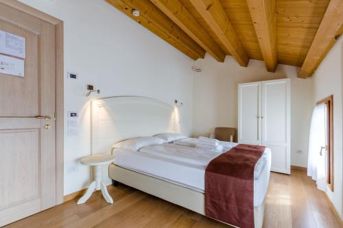 a bedroom with a large bed and a wooden ceiling at Tenuta Sant'Eufemia in San Pietro di Feletto