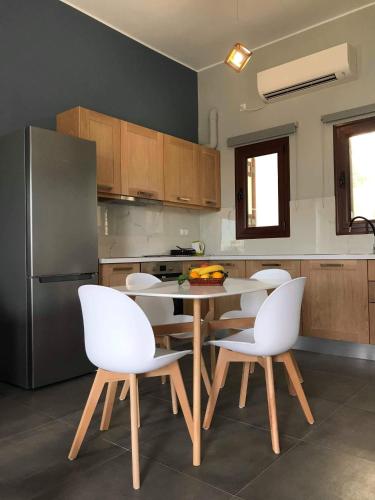 a kitchen with a table and chairs and a refrigerator at Light blue studios 2 in Poúlithra