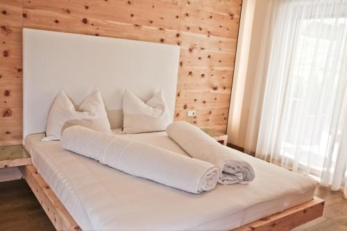 Bett in einem Zimmer mit einer Holzwand in der Unterkunft El Paradiso in Naturns