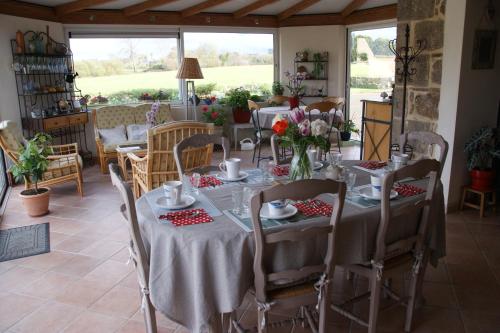 - une salle à manger avec une table et des fleurs dans l'établissement La Kerandière, à Tonquédec