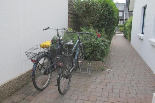 a bike parked on a brick sidewalk next to a building at Mowennest Morsum in Morsum