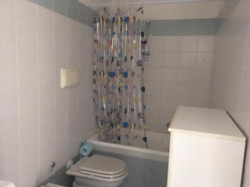 a bathroom with a shower curtain and a toilet at Gugliormella in Sirolo