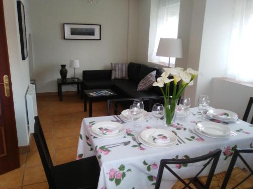 a dining room table with a vase of flowers on it at El Chalet Rosso in Guarnizo