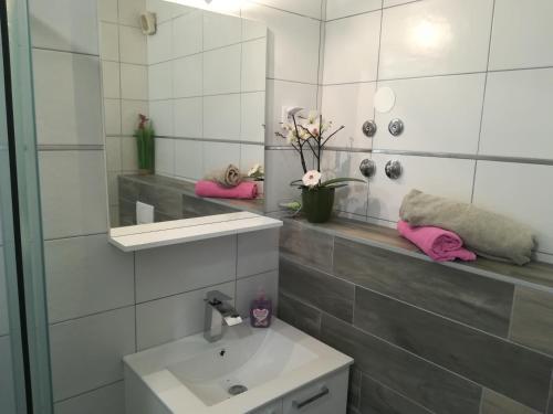 a white bathroom with a sink and a mirror at Guesthouse Porec in Poreč